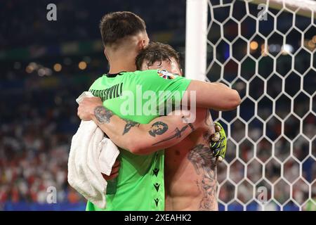 Gelsenkirchen, Allemagne. 26 juin 2024. Giorgi Mamardashvili et Guram Kashia, de Géorgie, s’enlacent alors qu’ils célèbrent la victoire de 2-0 et le passage aux éliminatoires avec leurs coéquipiers devant les supporters après le coup de sifflet final du match des Championnats d’Europe de l’UEFA à l’Arena Aufschalke, Gelsenkirchen. Le crédit photo devrait se lire : Jonathan Moscrop/Sportimage crédit : Sportimage Ltd/Alamy Live News Banque D'Images