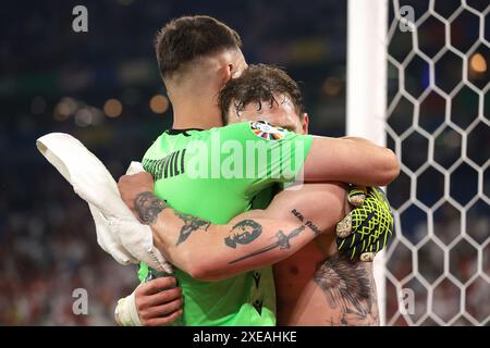 Gelsenkirchen, Allemagne. 26 juin 2024. Giorgi Mamardashvili et Guram Kashia, de Géorgie, s’enlacent alors qu’ils célèbrent la victoire de 2-0 et le passage aux éliminatoires avec leurs coéquipiers devant les supporters après le coup de sifflet final du match des Championnats d’Europe de l’UEFA à l’Arena Aufschalke, Gelsenkirchen. Le crédit photo devrait se lire : Jonathan Moscrop/Sportimage crédit : Sportimage Ltd/Alamy Live News Banque D'Images