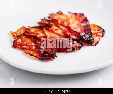 Assiette avec de savoureuses tranches de bacon sur pierre Banque D'Images