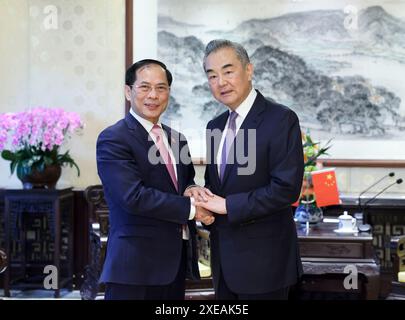 Pékin, Chine. 26 juin 2024. Le ministre chinois des Affaires étrangères Wang Yi, également membre du Bureau politique du Comité central du Parti communiste chinois, rencontre le ministre vietnamien des Affaires étrangères Bui Thanh son à Pékin, capitale de la Chine, le 26 juin 2024. Crédit : Ding Haitao/Xinhua/Alamy Live News Banque D'Images