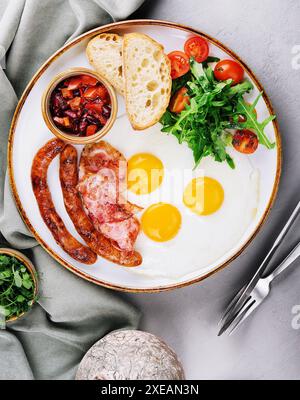 Oeufs frits et bacon pour le petit déjeuner dans une assiette Banque D'Images