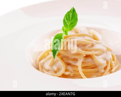 Spaghetti à la sauce crème blanche sur assiette blanche Banque D'Images