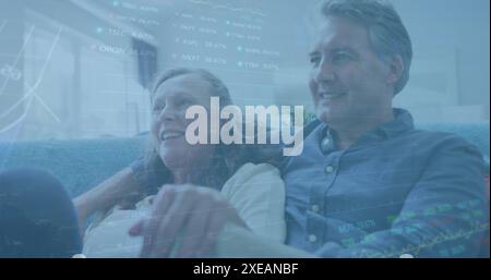 Image de graphiques et de tableaux de négociation sur un couple de personnes âgées caucasiennes passant du temps de qualité à la maison Banque D'Images