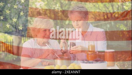 Image du drapeau des états-unis sur des amies féminines caucasiennes senior mangeant le dîner à l'extérieur Banque D'Images