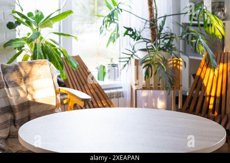 Table ronde vide pour l'installation et la démonstration du produit à l'intérieur avec des plantes tropicales d'intérieur dans la maison verte de pays. Banque D'Images