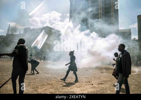 Les manifestants fuient les gaz lacrymogènes lors d'une manifestation contre le projet de loi de finances en 2024, dans le centre de Nairobi, le 25 juin 2024. Mardi, la police kenyane a tiré des gaz lacrymogènes sur une foule de jeunes manifestants dans la capitale Nairobi, alors que les manifestants se rassemblaient à travers le pays contre les augmentations d'impôts proposées par le gouvernement. Photo de Sadat Swaka/UPI crédit : UPI/Alamy Live News Banque D'Images