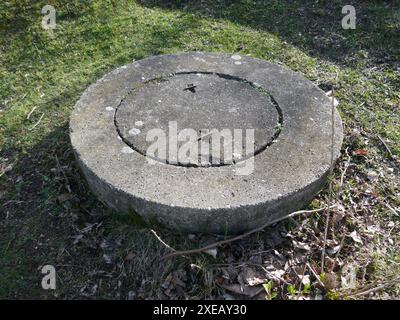 Trappe utilitaire de trou d'homme en béton à l'extérieur dans l'herbe Banque D'Images