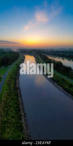 Reflet de l'aube : lever du soleil sur un canal calme Banque D'Images