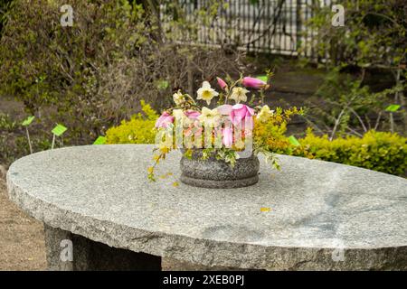 Grande table ronde en pierre sur belle terrasse, patio jardin. Endroit vide pour se détendre en plein air dans la cour arrière. Fleurs en pot vintage. Co Banque D'Images