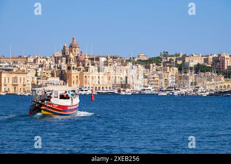 Le navire de Captain Morgan Cruises Company passe sur la baie le long de la côte de Birgu, Malte. Banque D'Images