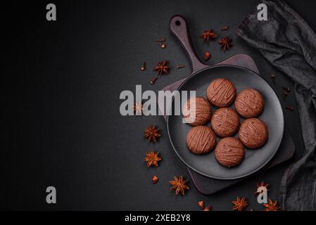 Délicieux biscuits au chocolat sucré sur une assiette en céramique noire Banque D'Images