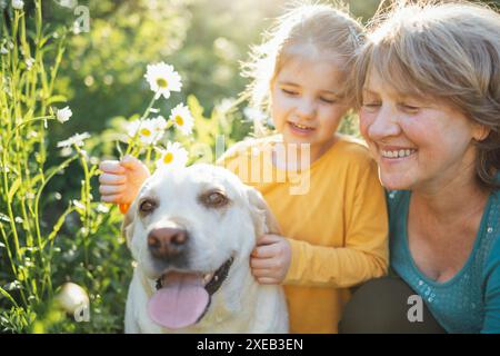 Grand-mère aux cheveux gris et petite-fille mignonne promènent leurs chiens ensemble dans le parc Banque D'Images