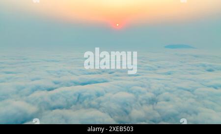 Vue aérienne d'un beau coucher de soleil vu de l'avion, vue au-dessus des nuages à une altitude de 800 mètres à long Coc, Vietnam Banque D'Images