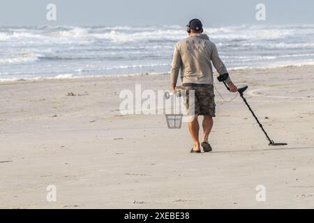 Florida Beachcomber avec détecteur de métaux portable scannant la plage de Jacksonville Beach dans le nord-est de la Floride. (ÉTATS-UNIS) Banque D'Images