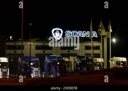 Varsovie, Pologne - 1er mai 2023 : vue nocturne d'un bâtiment d'usine de Scania avec plusieurs camions garés devant. Banque D'Images