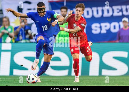 Dortmund, Allemagne. 25 juin 2024. Kylian Mbappe (à gauche), de France, et Nicola Zalewski (à droite), de Pologne, sont en action lors du match de la phase de groupes de l'UEFA EURO 2024 opposant la France et la Pologne au stade de football Dortmund (signal Iduna Park). Score final : France 1:1 Pologne. Crédit : SOPA images Limited/Alamy Live News Banque D'Images