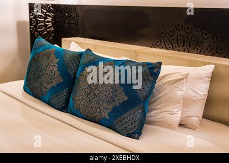 Oreiller rayé avec draps sur la tête de lit dans le lit d'hôtel Banque D'Images
