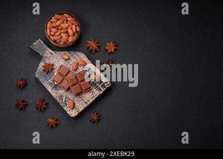 Délicieux chocolat au lait sucré cassé en cubes sur une planche à découper en bois Banque D'Images