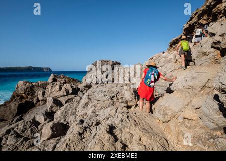 Famille marchant vers la plage de Coll Baix Banque D'Images