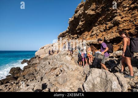 Famille marchant vers la plage de Coll Baix Banque D'Images