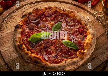 Pizza maison à base de fromage, bacon, saucisses et sauce au piment fort Banque D'Images