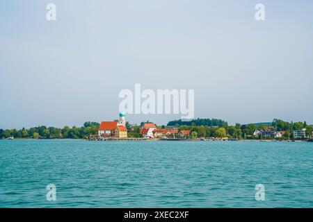 Allemagne, Wasserburg, église historique ville port lac bodensee vue panoramique de l'eau du bord de l'eau à la côte tôt le matin en été Banque D'Images