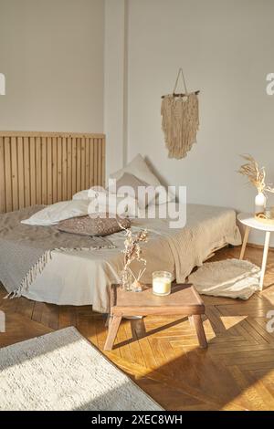 Intérieur confortable avec lit, tapis, plaid, plateau de petit déjeuner. Mobilier d'appartement. Fond beige en bois de maison Banque D'Images