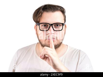 Homme sérieux avec le doigt sur les lèvres geste essaie de garder la conspiration, shh, silence s'il vous plaît. Banque D'Images