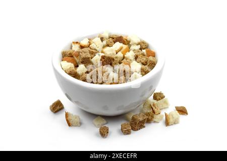 Croûtons de pain sur un fond blanc. Pile dispersée de croûtons de pain de seigle faits maison isolés sur fond blanc. Cubes de pain croustillants, chapelure de seigle sèche. Banque D'Images