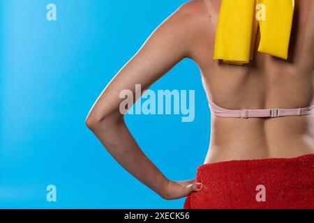 Une femme dans un grand chapeau de plage tient ses mains sur ses hanches. Banque D'Images