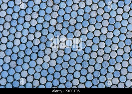 Fond abstrait avec des carreaux de céramique ronds principalement bleu clair, mais aussi des carreaux dans d'autres couleurs pastel. Banque D'Images