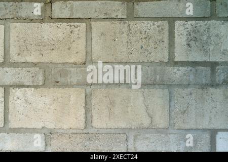Fond de maçonnerie abstrait avec des briques de différentes tailles. Mur déjà altéré et avec des fissures. Banque D'Images