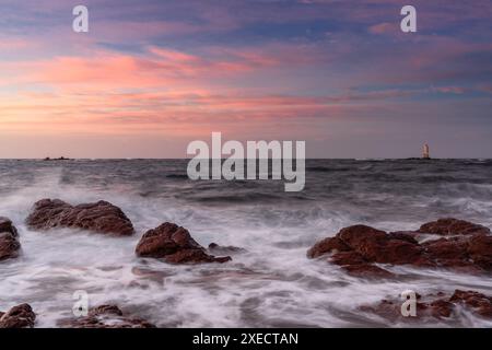 Vue sur la côte de l'île de Sant'Antioco et le phare de Mangiabarche au lever du soleil sur la Sardaigne Banque D'Images