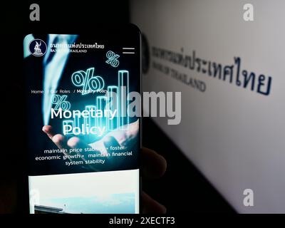 Personne tenant smartphone avec la page Web de l'institution financière thaïlandaise Banque de Thaïlande (BOT) devant le logo. Concentrez-vous sur le centre de l'écran du téléphone. Banque D'Images