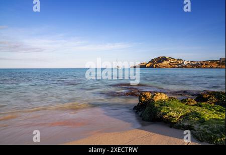 Vue sur la baie idyllique et la plage de Cala Agulla dans l'est de Majorque avec un voilier au premier plan Banque D'Images