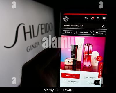 Personne tenant smartphone avec le site Web de la société cosmétique japonaise Shiseido Co. Ltd devant le logo. Concentrez-vous sur le centre de l'écran du téléphone. Banque D'Images