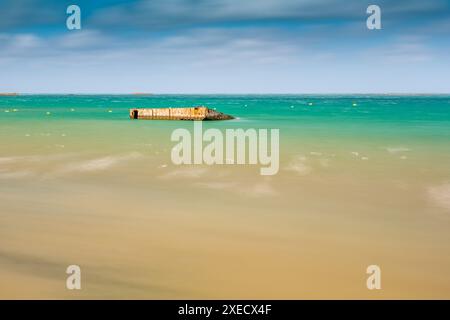 Photo tranquille longue exposition du Mulberry B reste sur Gold Beach, Arromanches, Normandie, France. Capture l'atmosphère sereine et le signe historique Banque D'Images