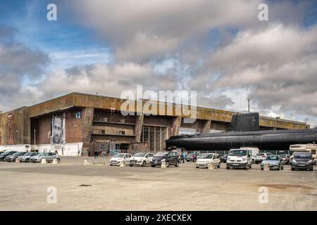 Base de sous-marins allemands de la seconde Guerre mondiale à Lorient, en Bretagne, en France, avec un sous-marin français des années 1960 amarré au milieu de grandes structures en béton. Banque D'Images