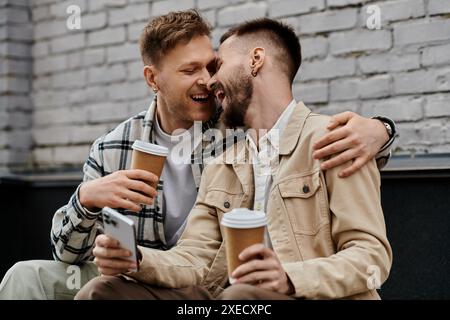 Deux hommes dans des tenues chics profitent du café ensemble à l'extérieur. Banque D'Images