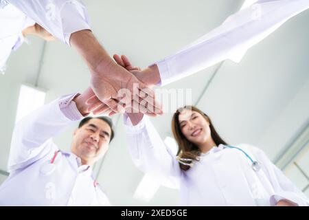 Les équipes médicales s’encouragent mutuellement avant de traiter des patients gravement malades à l’hôpital. Banque D'Images