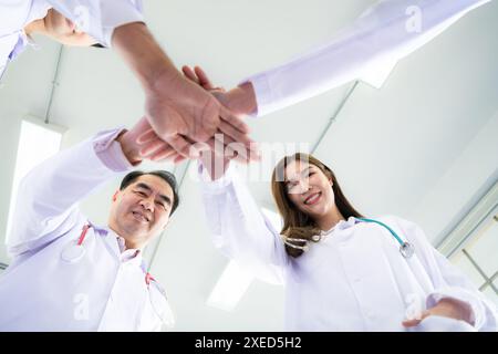 Les équipes médicales s’encouragent mutuellement avant de traiter des patients gravement malades à l’hôpital. Banque D'Images