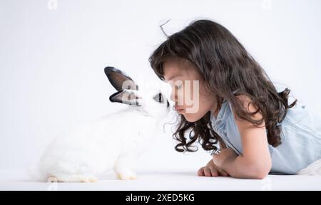 Une petite fille embrasse son lapin moelleux bien-aimé, la beauté de l'amitié entre les humains et les animaux Banque D'Images