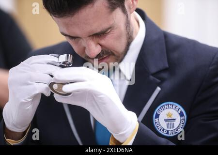 Sveta Nedelja, Croatie. 27 juin 2024. Victor Fenes, officier du Livre Guinness des records du monde, regarde la plus petite pièce du monde, à Sveta Nedjelja, Croatie, le 27 juin 2024. Hum, connue comme la plus petite ville du monde, apparaît sur la plus petite pièce du monde, émise par la Banque nationale croate et frappée par la monnaie croate. Le diamètre de la pièce d'or est de 1,99 millimètres et elle pèse 0,05 grammes. Photo : Robert Anic/PIXSELL crédit : Pixsell/Alamy Live News Banque D'Images