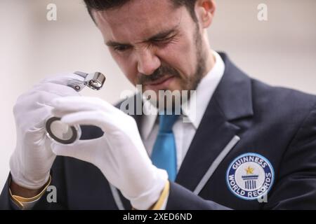 Sveta Nedelja, Croatie. 27 juin 2024. Victor Fenes, officier du Livre Guinness des records du monde, regarde la plus petite pièce du monde, à Sveta Nedjelja, Croatie, le 27 juin 2024. Hum, connue comme la plus petite ville du monde, apparaît sur la plus petite pièce du monde, émise par la Banque nationale croate et frappée par la monnaie croate. Le diamètre de la pièce d'or est de 1,99 millimètres et elle pèse 0,05 grammes. Photo : Robert Anic/PIXSELL crédit : Pixsell/Alamy Live News Banque D'Images