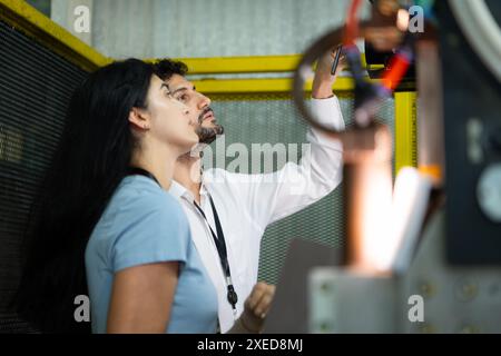 Homme d'affaires de l'inspection de l'industrie d'usine et de l'essai du bras de robots pour une utilisation dans les industries de fabrication complexes à grande échelle. Banque D'Images