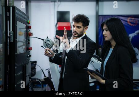 Homme d'affaires de l'inspection de l'industrie d'usine et de l'essai du bras de robots pour une utilisation dans les industries de fabrication complexes à grande échelle. Banque D'Images