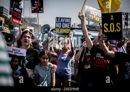 Tel Aviv, Israël. 27 juin 2024. Les familles d'otages et leurs partisans chantent et brandissent des pancartes alors qu'ils bloquent l'autoroute Ayalon à tel Aviv. Les organisations de protestation antigouvernementales ont lancé jeudi une journée de manifestations dans tout le pays, bloquant les principales autoroutes et appelant Israël à faire avancer un accord pour libérer les otages détenus par le Hamas à Gaza, pour mettre fin à la guerre et pour l'éviction du premier ministre Benjamin Netanyahu et des élections anticipées. Crédit : SOPA images Limited/Alamy Live News Banque D'Images