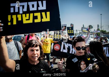 Tel Aviv, Israël. 27 juin 2024. Les familles d'otages et leurs partisans chantent et brandissent des pancartes qui disent "S.O.S" et en hébreu "Deal Now" alors qu'ils bloquent l'autoroute Ayalon à tel Aviv. Les organisations de protestation antigouvernementales ont lancé jeudi une journée de manifestations dans tout le pays, bloquant les principales autoroutes et appelant Israël à faire avancer un accord pour libérer les otages détenus par le Hamas à Gaza, pour mettre fin à la guerre et pour l'éviction du premier ministre Benjamin Netanyahu et des élections anticipées. Crédit : SOPA images Limited/Alamy Live News Banque D'Images