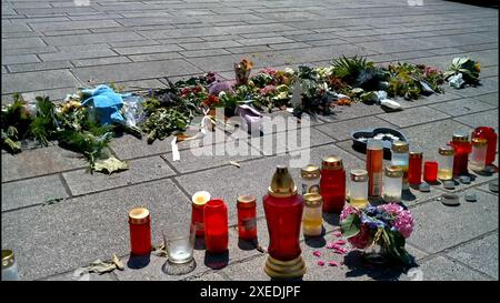 Bad Oeynhausen, Allemagne. 26 juin 2024. Les fleurs gisent et les bougies se tiennent sur le trottoir alors que les gens pleurent après une attaque fatale dans les jardins du spa. Après l'attaque fatale dans les jardins thermaux de Bad Oeynhausen, la police a arrêté un suspect de 18 ans. Un homme de 20 ans a subi des blessures extrêmement graves lors de l'attaque et est mort à l'hôpital peu de temps après. Une escouade des homicides enquête sur l'affaire pour homicide involontaire coupable et lésions corporelles graves. Crédit : Sandra Knauthe/TNN/dpa/Alamy Live News Banque D'Images