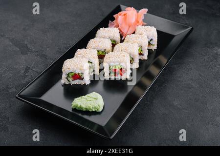 rouleaux de sushi maki végétariens avec graines de sésame sur plaque noire Banque D'Images